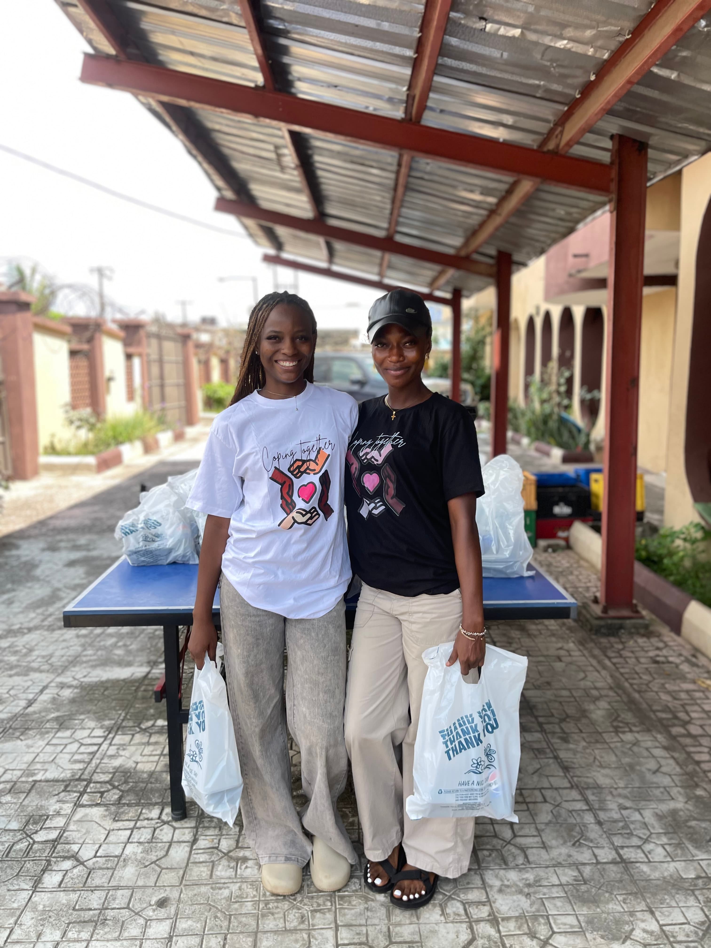 Volunteers smiling while holding the prepared pack